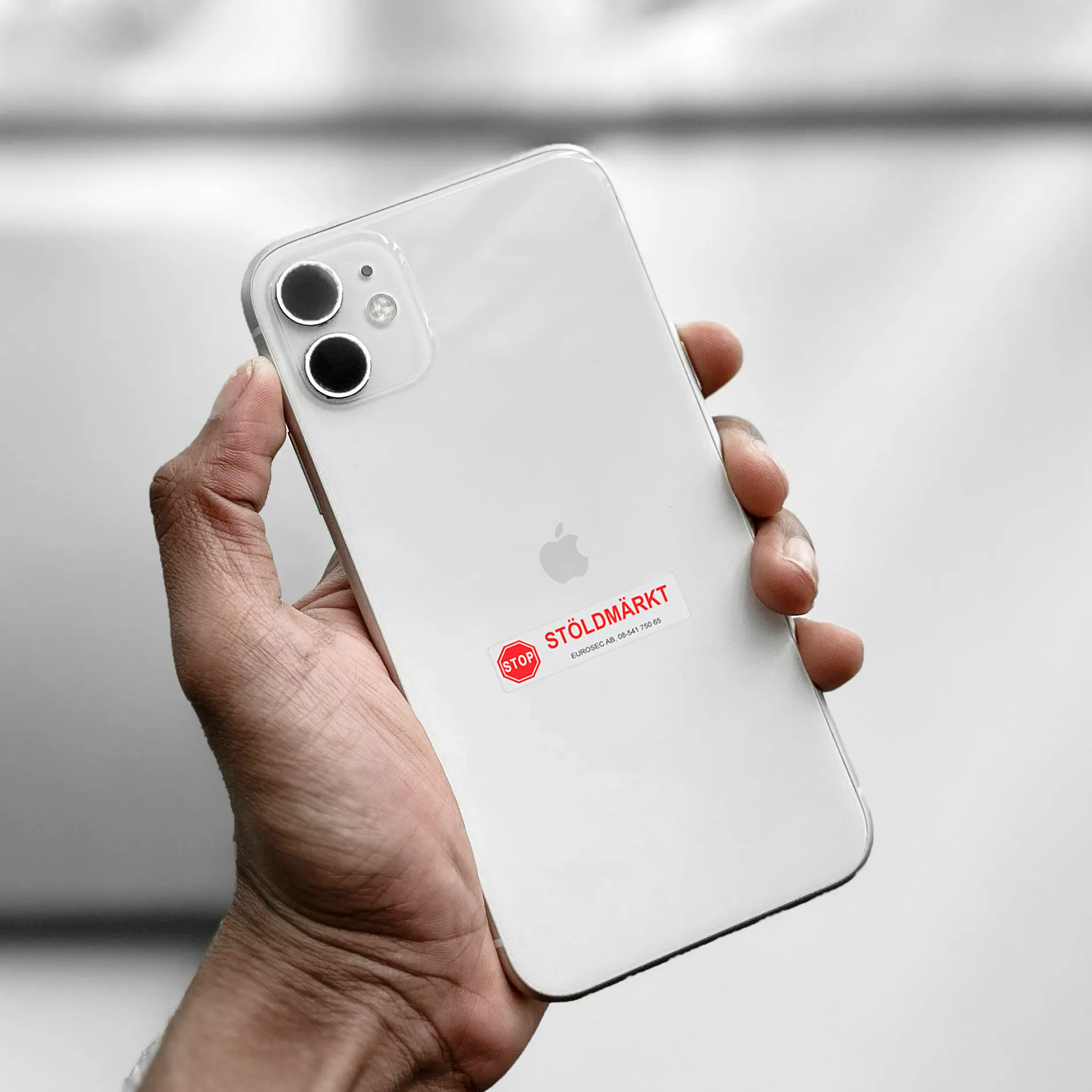 Vit iPhone med stöldmärkning från Eurosec – tydlig röd text med ordet ”stöldmärkt” som signalerar att enheten är skyddad mot stöld.