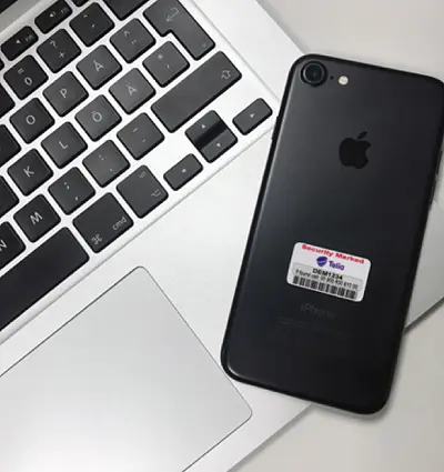 stöldmärkning som sitter på baksidan av en svart iphone