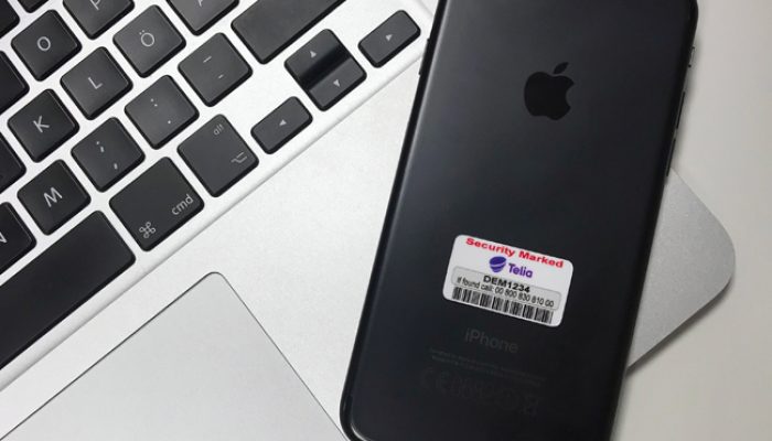 Stöldmärkning från Eurosec applicerad på svart iPhone – exempel på märkning för mobiltelefoner inom företag och offentlig verksamhet.